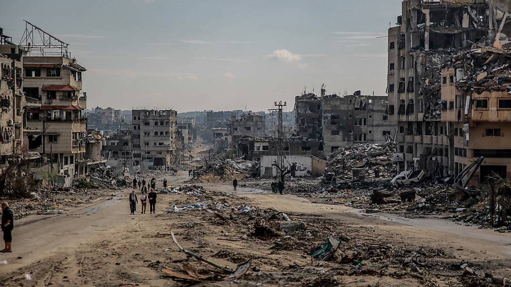 Palästinenser gehen durch die Überreste des zerstörten Scheich-Radwan-Viertels in Gaza-Stadt. Foto: Omar Ishaq/dpa