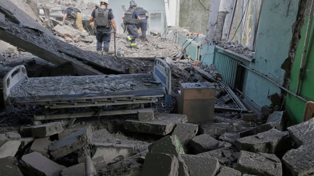 Rettungskräfte räumen die Trümmer auf, nachdem eine russische Gleitbombe ein städtisches Krankenhaus getroffen hat. Foto: Yevhen Titov/AP/dpa