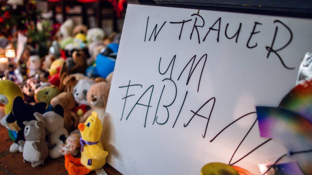 ARCHIV - Kerzen, Plüschtiere und ein Schild «In Trauer um Fabian» stehen vor dem Beginn des Trauergottesdienstes zum Abschied des achtjährigen Fabian am Eingang zur Marienkirche. Die Leiche des Kindes war am 14.10.2025, vier Tage nach seinem Verschwinden, in einem Wald nahe Güstrow gefunden worden. Foto: Jens Büttner/dpa