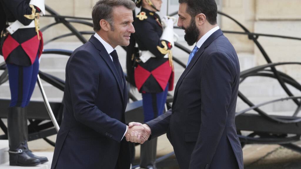 ARCHIV - Der französische Präsident Emmanuel Macron (l) begrüßt den syrischen Interimspräsidenten Ahmed al-Scharaa vor ihren Gesprächen im Elysee-Palast. Foto: Michel Euler/AP/dpa