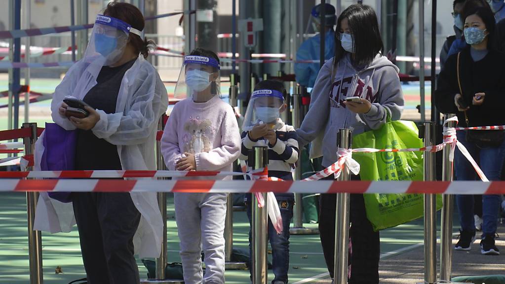 Menschen in Hongkong warten auf ihren Corona-Test. Die Millionenstadt wird von einer neuen Infektionswelle heimgesucht.