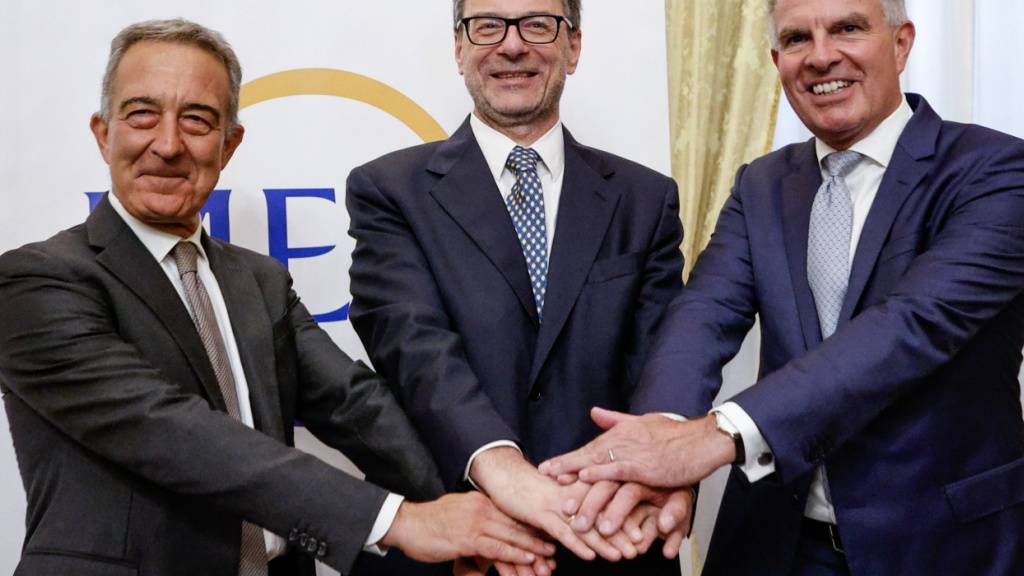 Der Präsident von ITA Airways, Antonino Turicchi, Italiens Wirtschaftsminister Giancarlo Giorgetti und Lufthansa-CEO Carsten Spohr (v.l.) geben sich während einer Pressekonferenz zum Zusammenschluss von ITA Airways und Lufthansa in Rom die Hand.