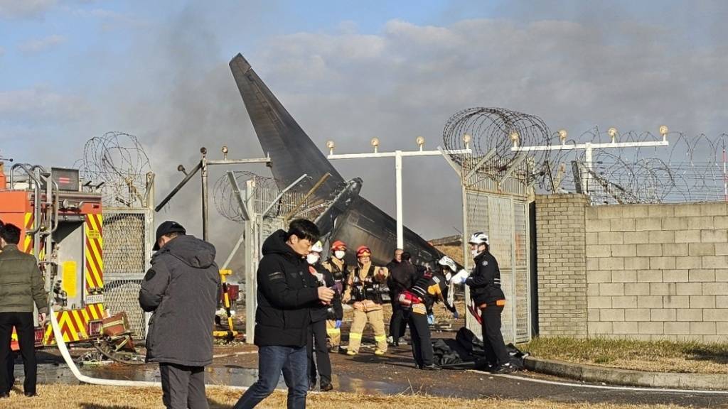 Feuerwehrleute und Mitglieder des Rettungsteams arbeiten auf dem internationalen Flughafen von Muan. Bei der Landung am internationalen Flughafen von Muan in Südkorea ist ein Passagierflugzeug verunglückt. Foto: Maeng Dae-hwan/Newsis/AP/dpa