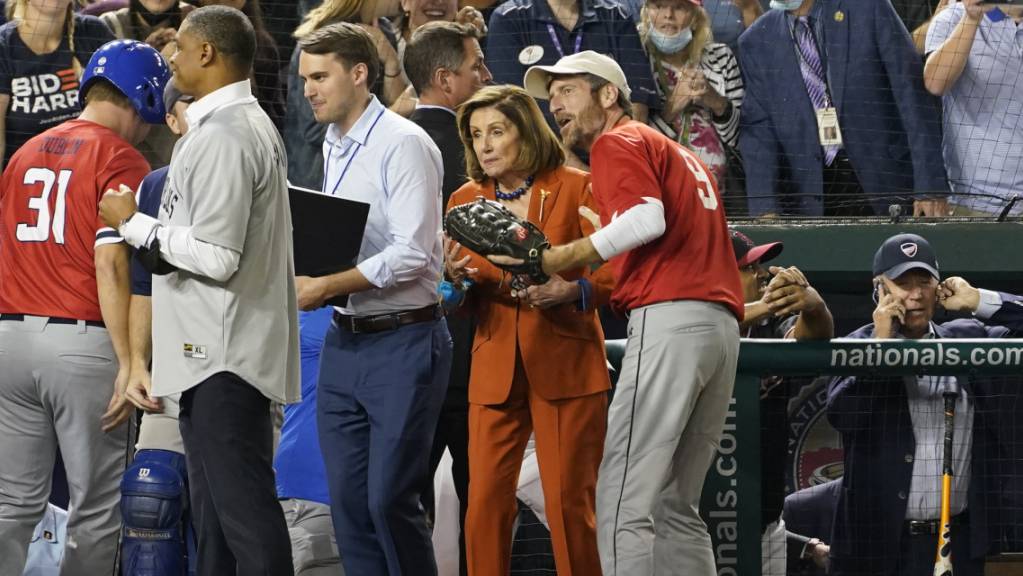 Präsident Joe Biden (r) telefoniert, während die Sprecherin des Repräsentantenhauses, Nancy Pelosi (M, Kalifornien) das Baseballspiel des Kongresses verfolgt. Inmitten angestrengter Verhandlungen im US-Kongress haben sich Parlamentarier und Präsident Joe Biden eine Pause gegönnt - beim Baseball. Foto: Susan Walsh/AP/dpa