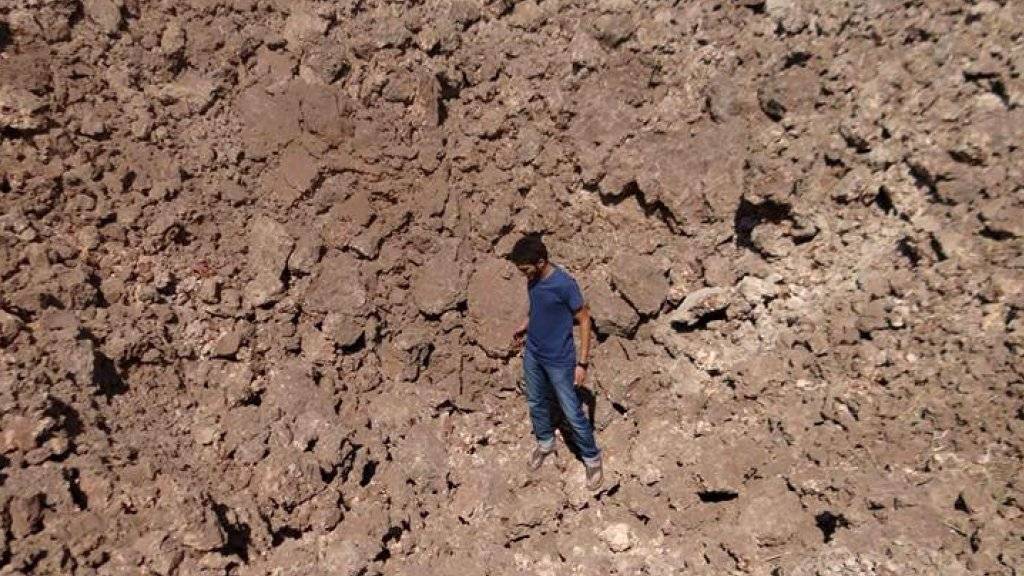 Ein Mann in einem durch eine abgeworfene Bombe entstandenen Krater in Sarakeb. In der syrischen Stadt soll bei einem Angriff am 4. Februar Giftgas eingesetzt worden sein. (Archiv)