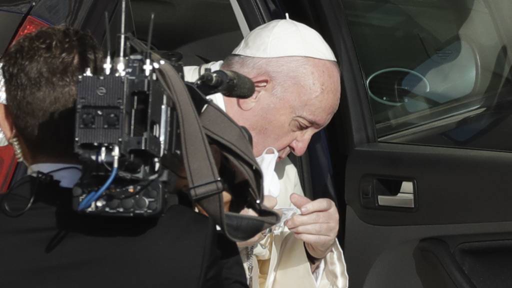 Papst Franziskus nimmt seinen Mundschutz ab, während er zu seiner wöchentlichen Generalaudienz eintrifft. Foto: Andrew Medichini/AP/dpa