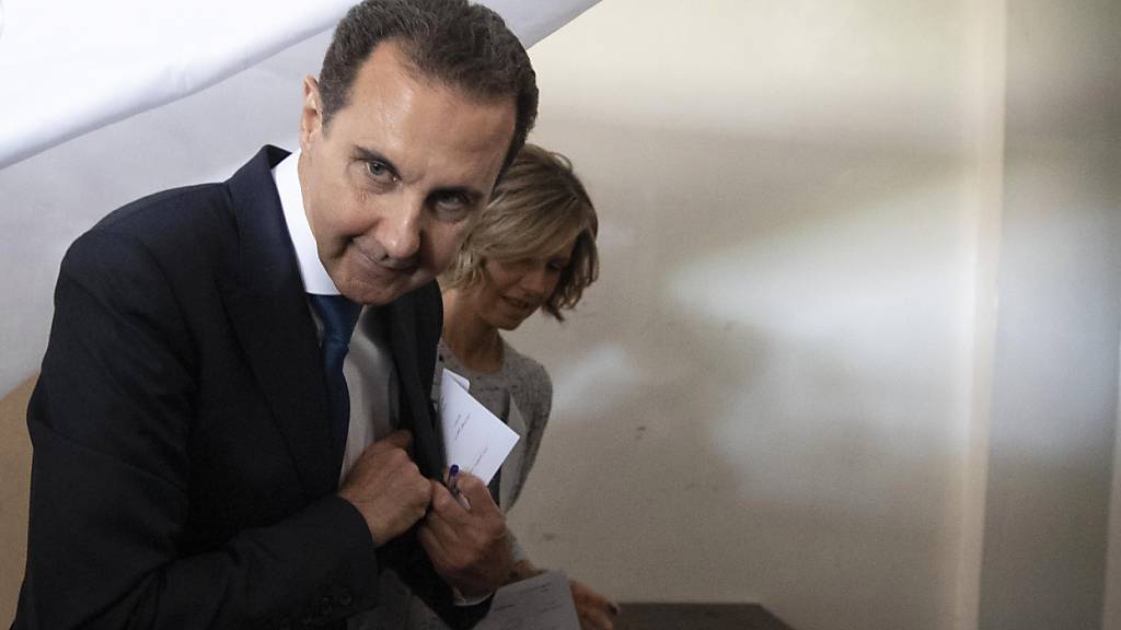ARCHIV - Der damalige syrische Präsident Baschar al Assad und seine Frau Asma bereiten sich auf die Stimmabgabe in einem Wahllokal in der Stadt Douma vor. Foto: Hassan Ammar/AP/dpa