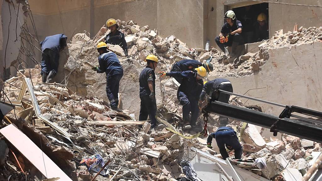 dpatopbilder - Mitglieder des ägyptischen Zivilschutzes arbeiten an Überresten des eingestürzten 13-stöckigen Gebäudes in Alexandria. Foto: Stringer/dpa