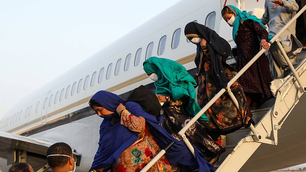 Mitglieder des US-Militärs helfen afghanischen Familien bei der Ankunft auf der Naval Air Station Sigonella (NAS) aus dem Flugzeug.
