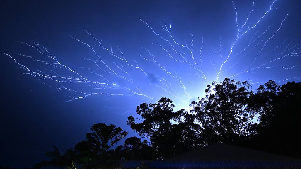 An electrical storm is seen at Reedy Creek on the Gold Coast Monday, December 25, 2023. A woman has died after being struck by a tree after winds of 100 kph lashed the Gold Coast, bringing down trees, powerlines. (AAP Image/Dave Hunt) NO ARCHIVING