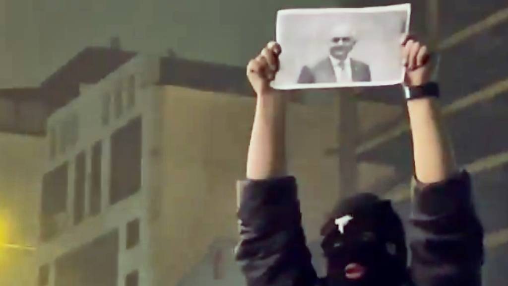 SCREENSHOT - In diesem Bild aus einem Video, das die Nachrichtenagentur AP außerhalb des Irans erhalten hat, hält ein maskierter Demonstrant ein Bild des iranischen Kronprinzen Reza Pahlavi während einer Demonstration in Teheran. Foto: Uncredited/UGC via AP/dpa - ACHTUNG: Nur zur redaktionellen Verwendung im Zusammenhang mit der aktuellen Berichterstattung und nur mit vollständiger Nennung des vorstehenden Credits
