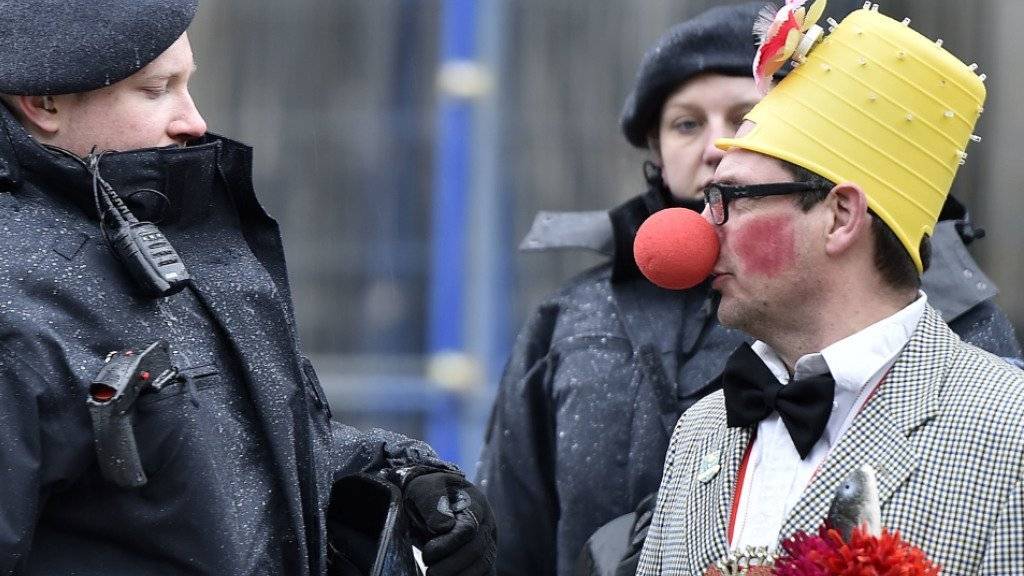 Ein Karnevalsteilnehmer spricht in Köln mit einem Polizisten: Nach den Übergriffen in der Silvesternacht sind die Ordnungshüter mit einem Grossaufgebot vor Ort.