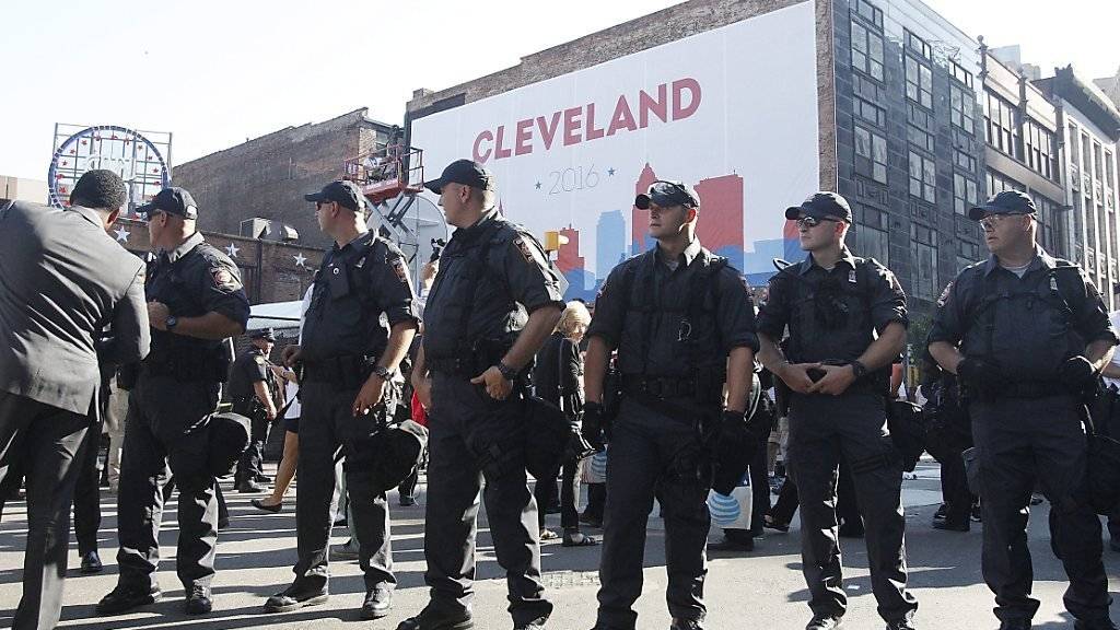 Polizisten sichern den Parteitag der US-Republikaner in Cleveland. Sie nahmen 17 Demonstranten fest, nachdem eine US-Fahne in Brand gesetzt worden war und die Flammen auf Protestierende übergriff.