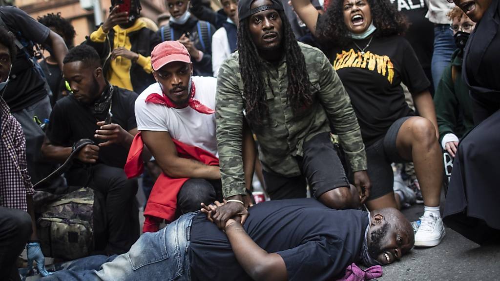 Demonstranten stellen in New York die Szene nach, die zum Tod von George Floyd führte. Der Protest der Demonstranten richtet sich gegen Rassismus und Polizeigewalt. Foto: Wong Maye-E/AP/dpa