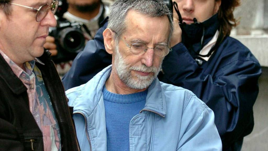 ARCHIV - Der französische Serienmörder Michel Fourniret (M) wird in Gerichtsgebäude gebracht. Der 79-Jährige starb am 10.Mai im Krankenhaus, wie die französische Nachrichtenagentur AFP unter Berufung auf die Staatsanwaltschaft berichtete. Foto: Boucau/BELGA/dpa