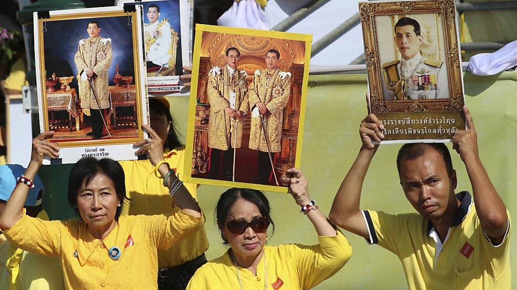 Lang lebe der König: Monarchisten in gelben Hemden halten Porträts ihrer neuen Königs in die Luft.