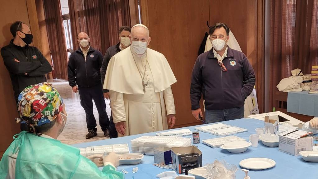 Papst Franziskus (Mitte) besucht am Karfreitag Bedürftige und Gesundheitspersonal im Corona-Impfzentrum des Vatikans.
