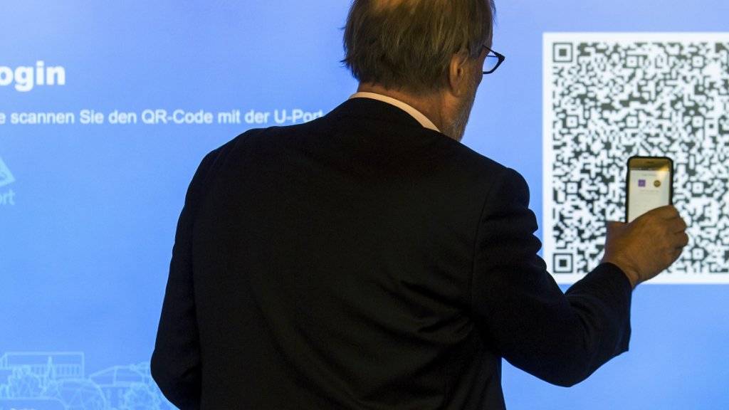 Der Zuger Stadtpräsident Dolfi Müller (SP) registriert sich auf der App, um mit seinem Handy an der ersten blockchain-basierten Abstimmung teilnehmen zu können. Die Stadt Zug will mit diesem E-Voting-System eine Vorreiterrolle in der Schweiz übernehmen.