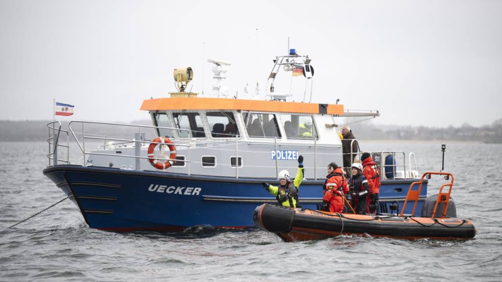 Umweltschützer und Einsatzkräfte stehen in der Nähe des Buckelwals. Nach seiner zwischenzeitlichen Befreiung von einer Sandbank liegt der Buckelwal noch immer in der Wismarer Bucht. Foto: Philip Dulian/dpa