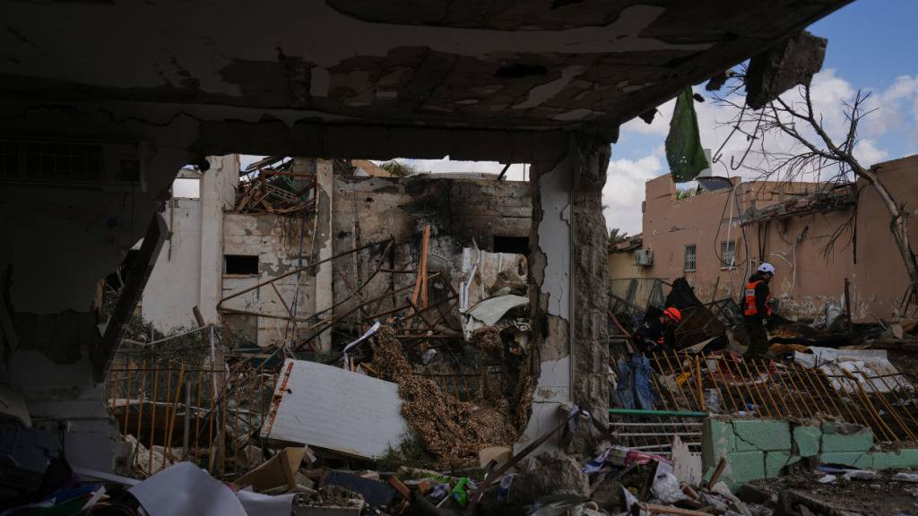 Israelische Sicherheitskräfte begutachten den Ort, an dem eine iranische Rakete eingeschlagen ist. Foto: Ariel Schalit/AP/dpa