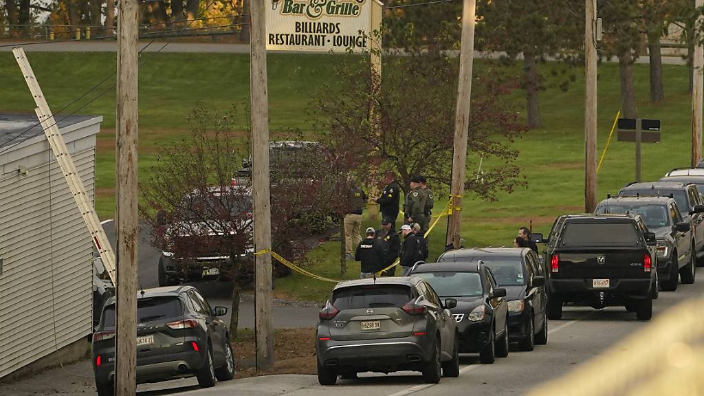 Polizeikräfte versammeln sich vor einer Gaststätte. Ein Schütze hat in Maine mehrere Menschen getötet und verletzt. Der mutmaßliche Täter ist auf der Flucht. Foto: Robert F. Bukaty/AP/dpa