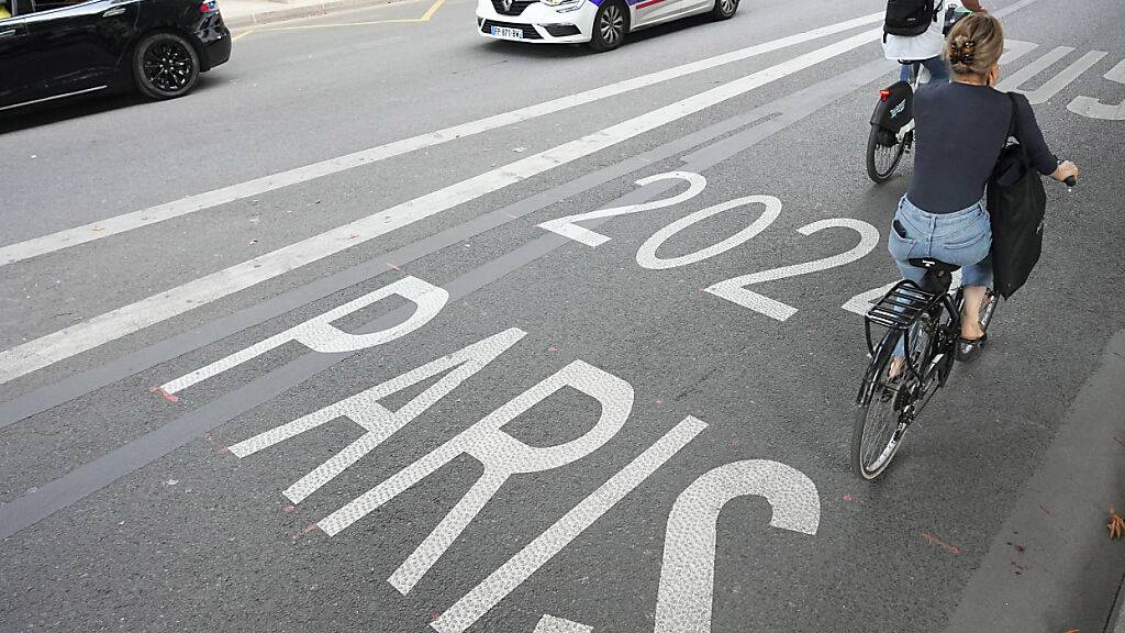 ARCHIV - Fahrradfahrer fahren auf einer Busspur in Paris an einem Polizeifahrzeug vorbei. Foto: Michael Kappeler/dpa