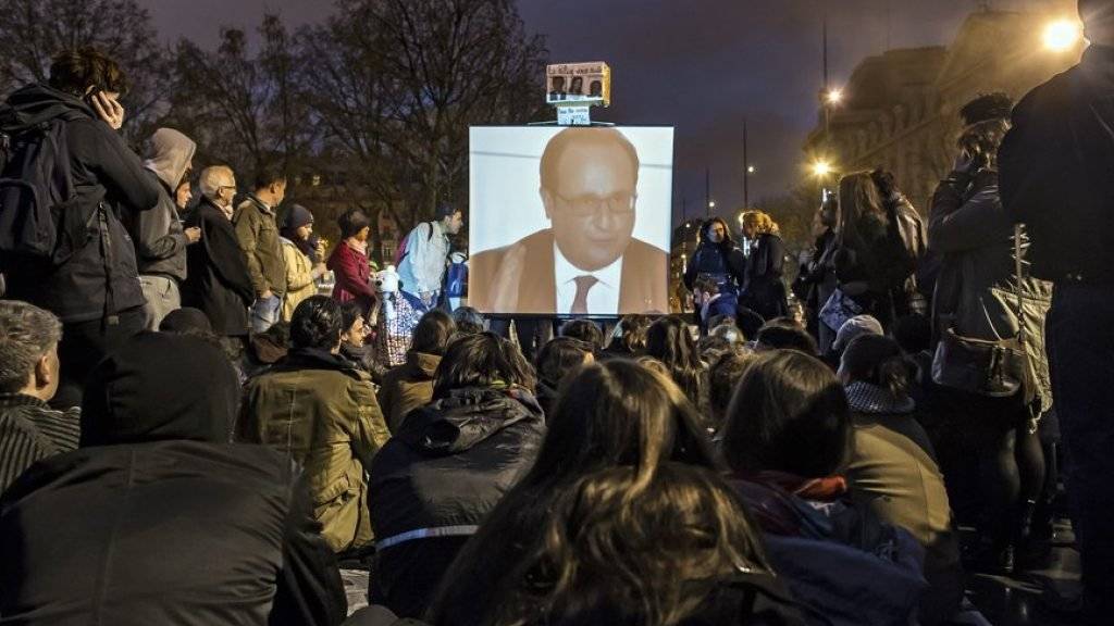 Demonstranten verfolgen an der Place de la République auf einer Leinwand ein Interview, in dem François Hollande die geplanten Massnahmen zum Arbeitsrecht verteidigt. Danach kam es in Paris zu Ausschreitungen.