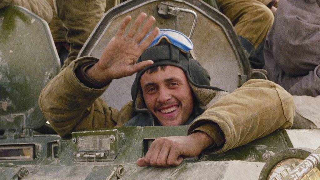 Mit einem Lächeln winkt ein sowjetischer Soldat am 7. Februar 1989 beim Abzug seiner Einheit aus Afghanistan aus Hayratan. Am Freitag gedachten in Moskau hunderte Veteranen des Abzugs. (Archivbild/KEYSTONE/AP Photo/Boris Yurchenko)