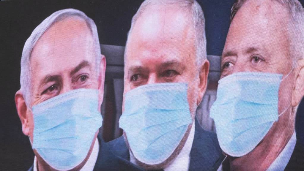 Grosse Qualition in Israel: Premierminister Benjamin Netanjahu, Rechtsaussen Avigdor Lieberman und Oppositionsführer Benny Gantz (von links) mit Mundschutz auf einem Plakat in Tel Aviv.
