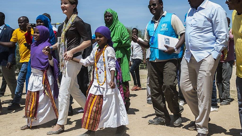 Die Schweizer Bundespräsidentin Simonetta Sommaruga mit zwei Flüchtlingskindern an der Hand im Sheder Flüchtlingslager