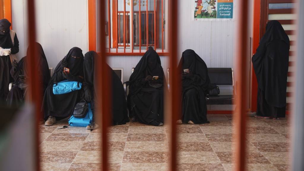 ARCHIV - Frauen warten in einem medizinischen Zentrum im Lager al-Hol, einer der Haftanstalten, in denen Tausende IS-Mitglieder und ihre Familien festgehalten werden und die nach dem Rückzug der Syrischen Demokratischen Kräfte (SDF) nun unter der Kontrolle der syrischen Regierung stehen. Foto: Ghaith Alsayed/AP/dpa