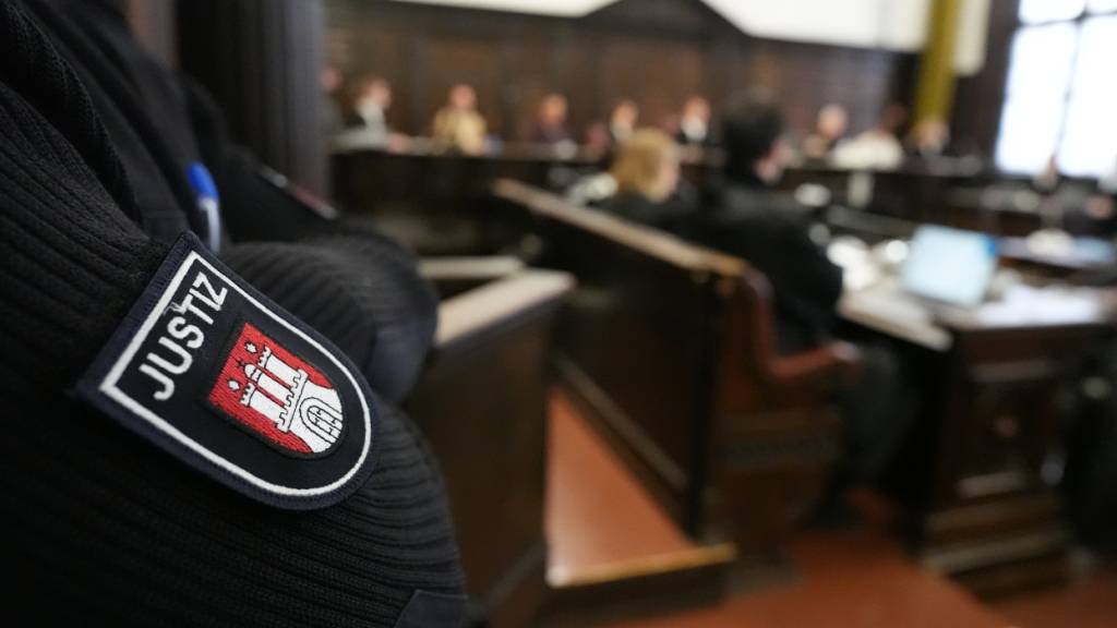 Ein Justizbeamter steht im Sitzungssaal zu Beginn des nicht-öffentlichen Prozesses «White Tiger» vor der Großen Strafkammer 27, einer Jugendkammer, im Strafjustizgebäude. Foto: Marcus Brandt/Pool dpa/dpa