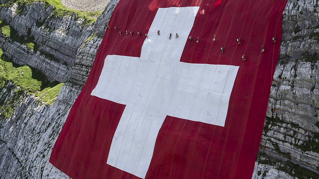 Die grösste Schweizerfahne hängt anlässlich des Nationalfeiertags an der Nordwand unterhalb des Säntis.