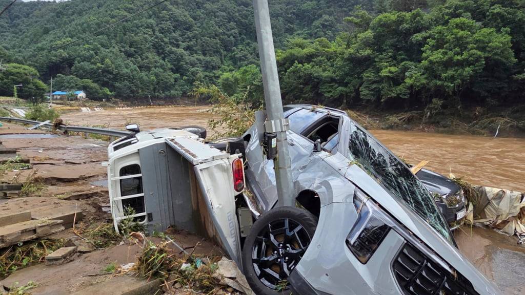 Beschädigte Fahrzeuge hängen an einem Masten nach schweren Regenfällen in Gapyeong, Südkorea. Foto: Shim Min-gyu/Yonhap via AP/dpa