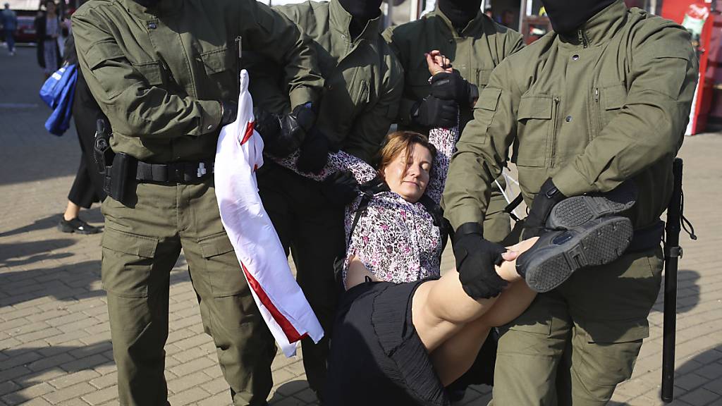 Polizisten tragen am Rande einer Demonstration in Minsk eine Frau weg. Foto: Uncredited/TUT.by/dpa