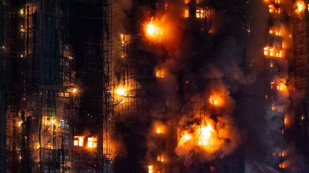 Feuerwehrleute arbeiten daran, ein Feuer zu löschen, das im Wang Fuk Court, einer Wohnsiedlung im Stadtteil Tai Po in den New Territories von Hongkong, ausbrach. Foto: Chan Long Hei/AP/dpa