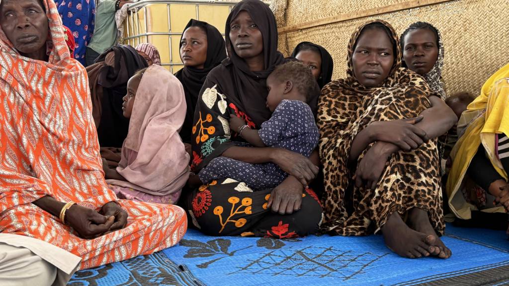 Flüchtlinge aus dem Sudan warten in der tschadischen Grenzstadt Adré auf dem Gelände des Roten Kreuzes auf den Weitertransport in ein Flüchtlingslager. Hinter einigen von ihnen liegt eine monatelange Odyssee durch die Kampfgebiete im Sudan. Foto: Eva Krafczyk/dpa