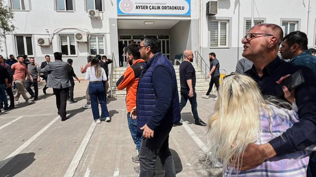 Menschen stehen auf dem Hof eines Gymnasiums in der Türkei, in dem ein Achtklässler das Feuer eröffnet hat. Foto: IHA/IHA via AP/dpa