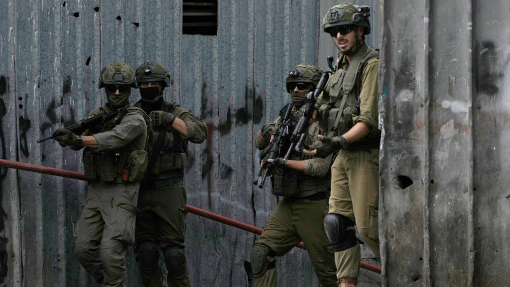 Angehörige der israelischen Sicherheitskräfte stehen während einer Militärrazzia in der Stadt im Westjordanland in einer Gasse Wache. Foto: Majdi Mohammed/AP/dpa