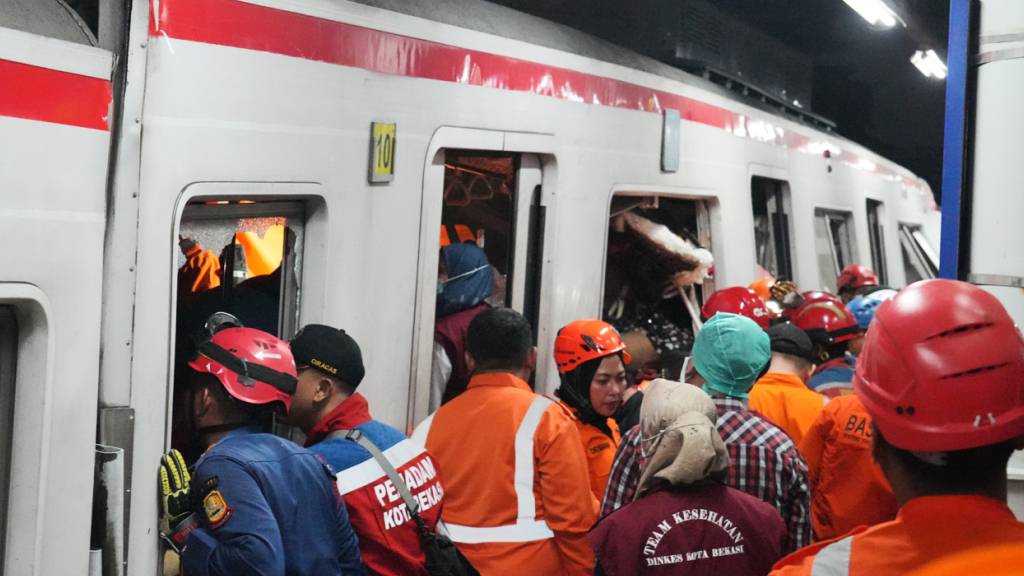 Rettungskräfte suchen nach einer Zugkollision in einem Bahnhof in Bekasi, Indonesien, nach Opfern. Foto: Ahmad Ibrahim/AP/dpa