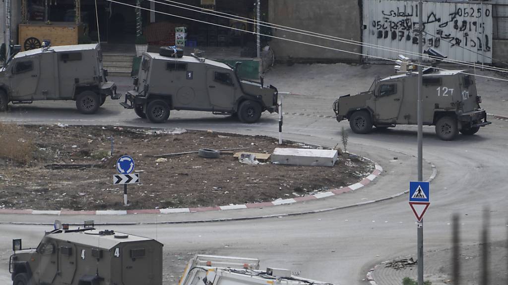 Fahrzeuge des israelischen Miltärs stehen auf einer Straße, während das israelische Militär eine Razzia im Flüchtlingslager Nur Shams im Westjordanland durchführt. Foto: Majdi Mohammed/AP/dpa