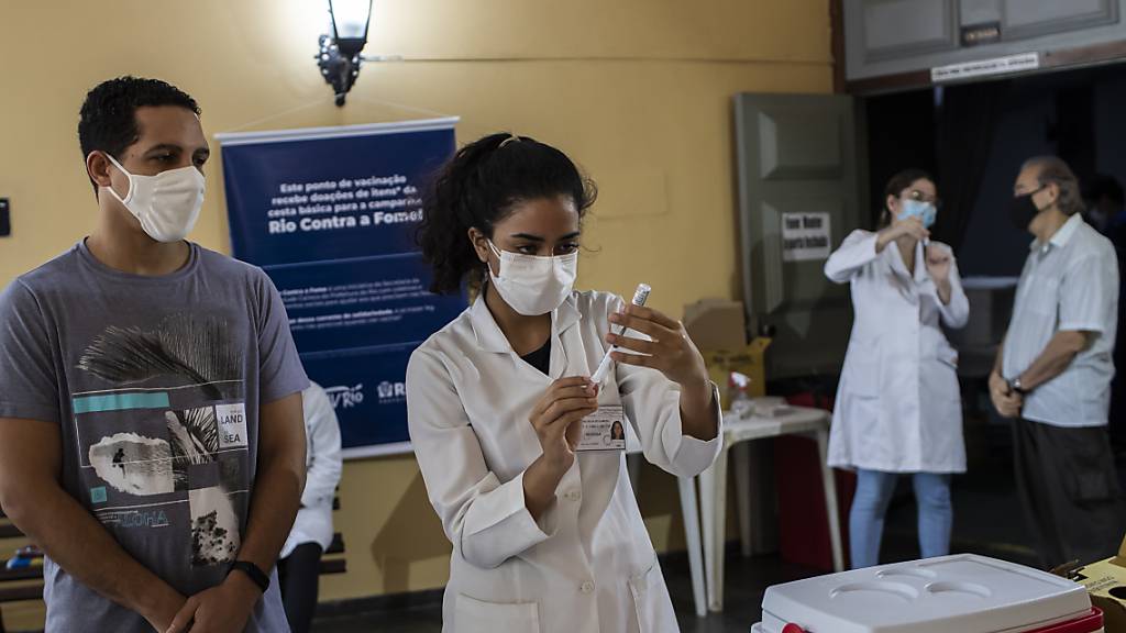 Eine Gesundheitsarbeiterin bereitet eine Spritze mit einem Corona-Impfstoff vor. Angesichts der verharmlosenden Politik der Regierung von Präsident Bolsonaro in Bezug auf die Pandemie sind tausende Brasilianer auf die Straße gegangen. Foto: Bruna Prado/AP/dpa