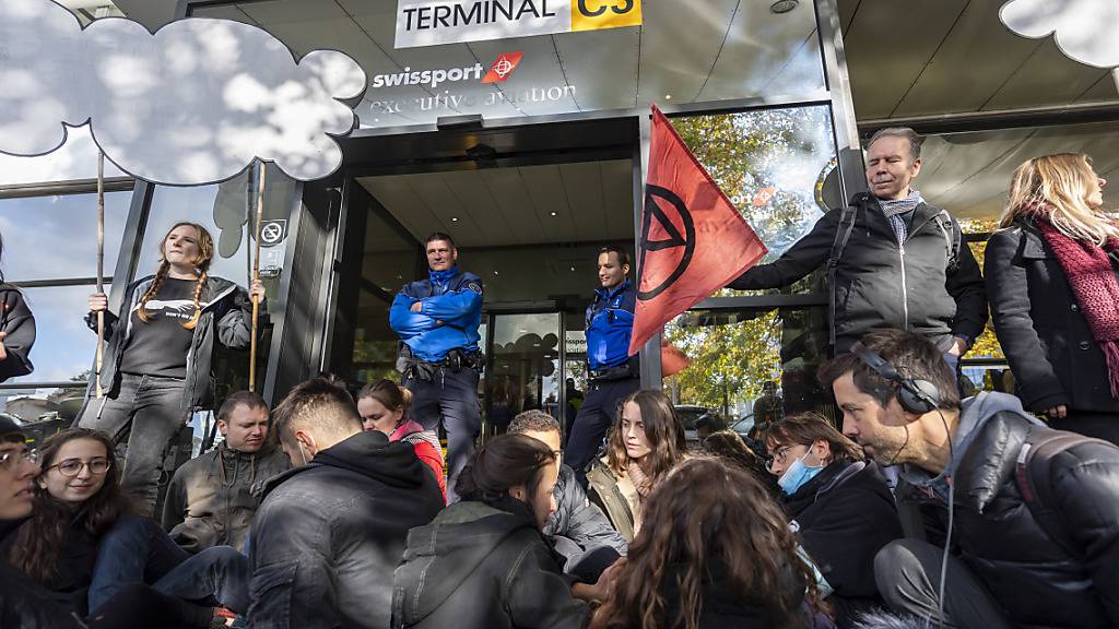 Rund 100 Aktivisten der Extinction Rebellion blockieren die Zufahrtsstrassen zum Privatjet-Terminal des Genfer Flughafens.