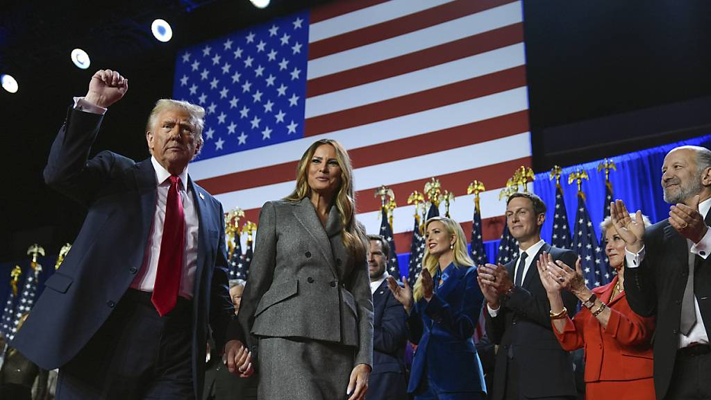 Der republikanische Präsidentschaftskandidat und frühere US-Präsidentschaftskandidat Donald Trump (l-r) gestikuliert neben der ehemaligen First Lady Melania Trump bei einer Wahlparty zu den US-Wahlen im Palm Beach Convention Center. Foto: Evan Vucci/AP/dpa