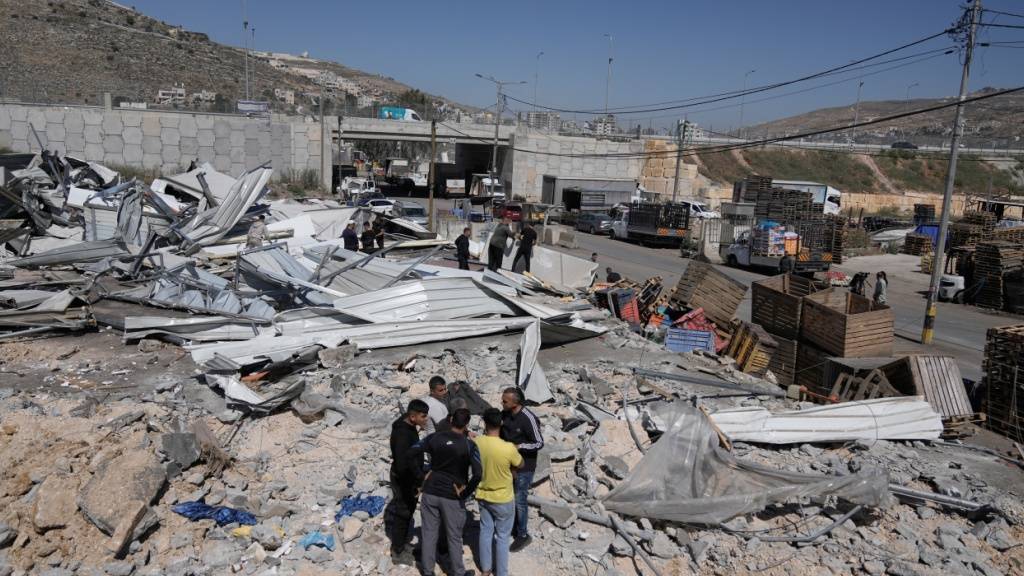 ARCHIV - Palästinenser gehen durch die Trümmer ihrer Häuser, nachdem die israelischen Behörden einen großen Teil des Hauptgemüsemarktes des Westbankdorfes Beita, südöstlich von Nablus, am Montag, den 1. Juni 2026, zerstört haben. Foto: Majdi Mohammed/AP/dpa