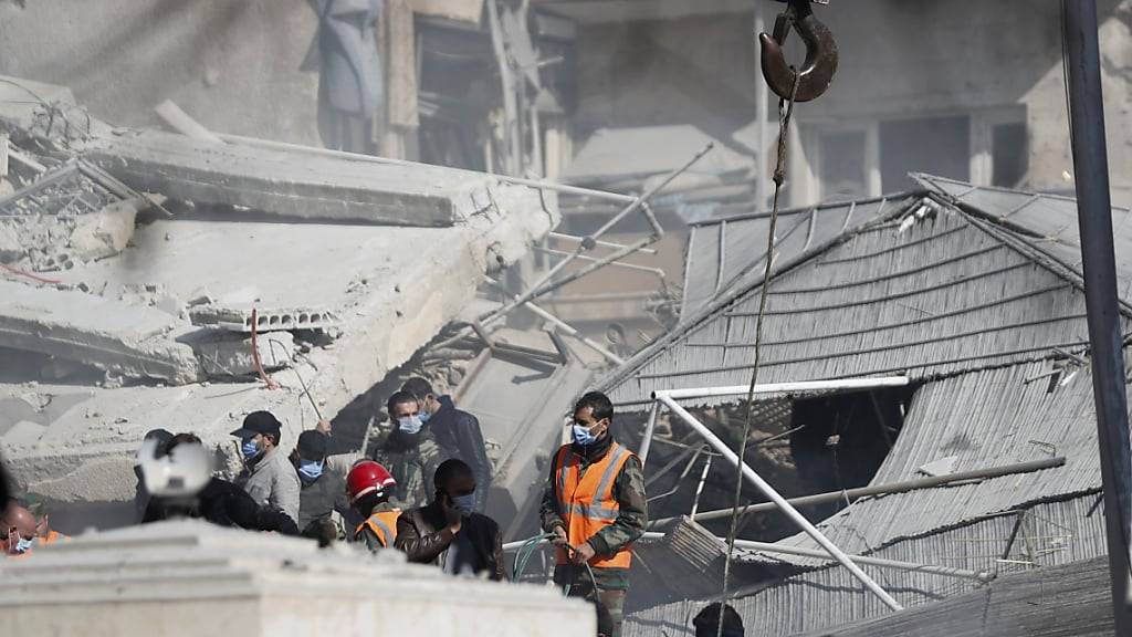 ARCHIV - Rettungskräfte arbeiten an einem von einem Luftangriff getroffenen Gebäude in der syrischen Hauptstadt Damaskus. Foto: Omar Sanadiki/AP/dpa