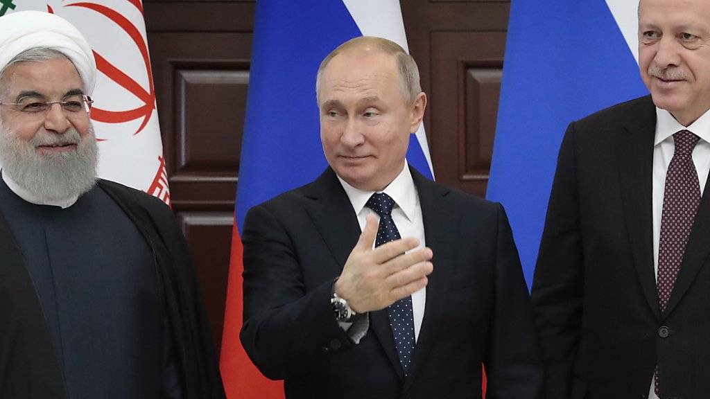 Russlands Präsident Wladimir Putin (Mitte) fordert am Syrien-Gipfel in Sotschi die USA auf, die Truppen rasch aus Syrien abzuziehen. Am Gipfel vereinbarte er mit dem türkischen  Staatschef Recep Tayyip Erdogan (rechts) und Irans Präsident Hassan Ruhani, das Vorgehen im Syrien zu koordinieren.