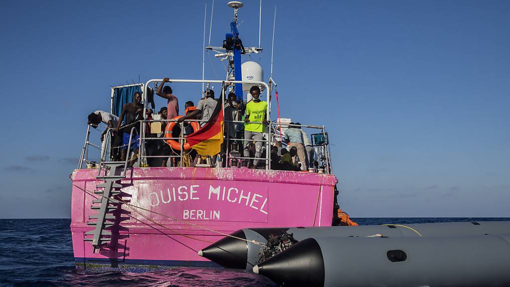 Migranten stehen an Bord des Rettungsschiffes «Louise Michel». Foto: Santi Palacios/AP/dpa