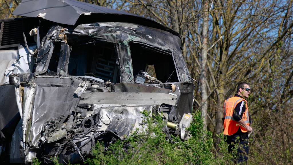Ein Arbeiter steht in der Nähe eines Hochgeschwindigkeitszuges (TGV), nachdem dieser in Bully-les-Mines mit einem Laster zusammengestoßen ist. Foto: Jean-Francois Badias/AP/dpa