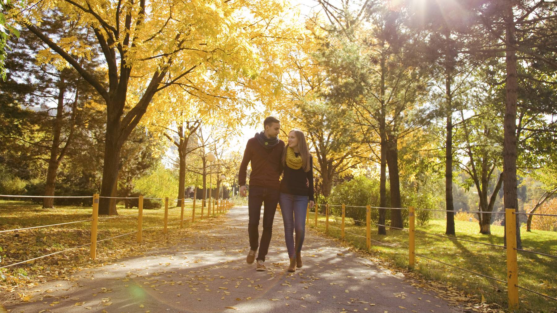 Ein Paar spaziert in einer Herbstlandschaft.